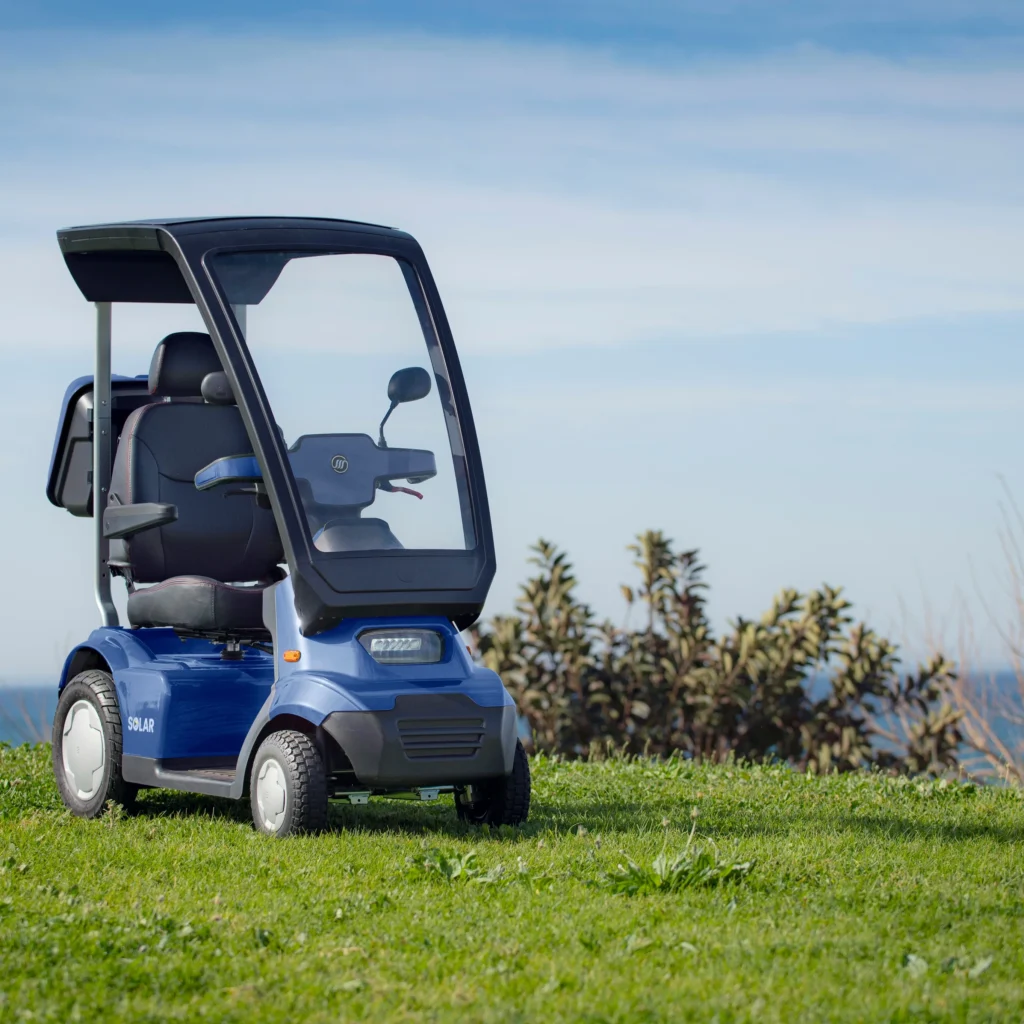 Afiscooter S4 Solar scooter parked near the ocean.